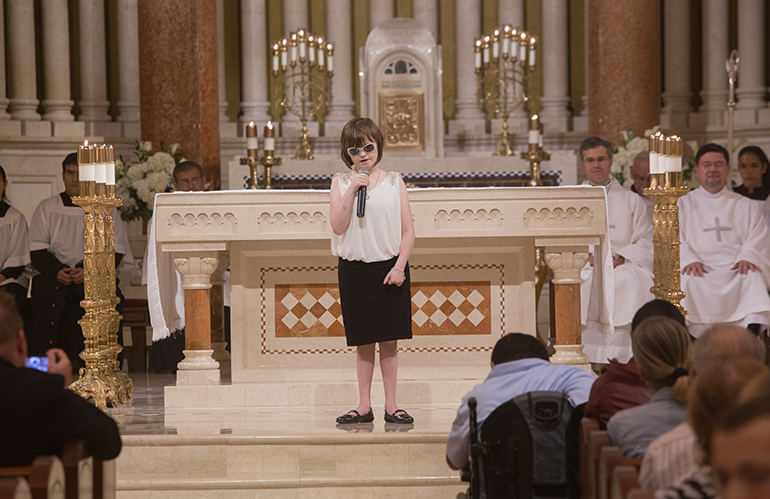 Marlana VanHoose, who is blind from birth, sings "Amazing Grace" at the end of the White Mass for persons with special needs celebrated at St. Patrick's, Miami Beach.