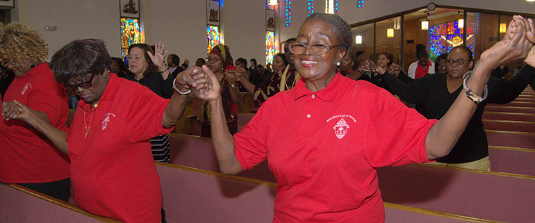 Lenora Gardner, right, lifts her hands and sings at the Black Catholic Mass. Holding hands with her is her mother, Ruth Gardner, who received an Award for Excellence Nov. 8 at the Black Catholic History Month luncheon in Sunny Isles Beach.