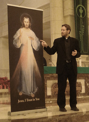 Father Michael Gaitley, of the Marian Fathers of the Immaculate Conception, points to the image of Divine Mercy during his talk at St. Gregory Church.