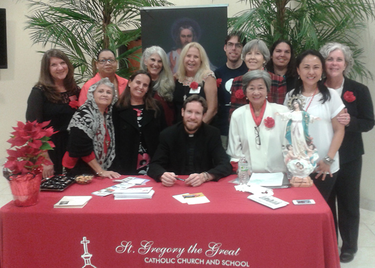 Father Michael Gaitley, of the Marian Fathers of the Immaculate Conception, poses with St. Gregory parishioners during his book signing.