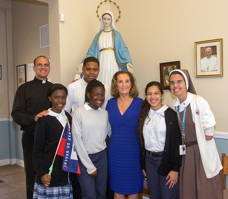 Posing for a photo at the entrance to St. Mary Cathedral School, from left: Father Christopher Marino, cathedral rector; Saskia Magloire, 14; David Barbier, 14; Briana Pierre, 14; Pamela White, U.S. ambassador to Haiti; Michelle Quant, 13, president of St. Mary's student council; and school principal Sister Michelle Fernandez of the Servants of the Pierced Hearts of Jesus and Mary.