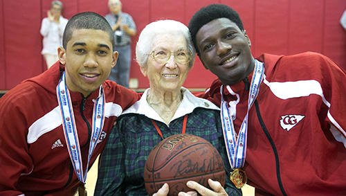 Franciscan Sister Marie Schramko, who has been at the school since it started and now serves as assistant principal of academics, helps the Cardinal Gibbons team celebrate their first state championship in basketball.