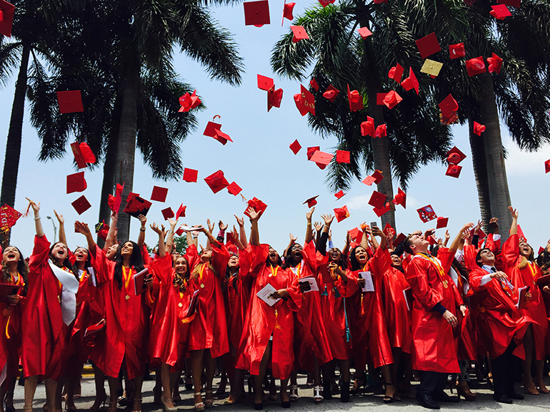 Members of Msgr. Edward Pace High School's class of 2015 toss their mortar boards sky high after their graduation ceremony May 22 at Dade County Auditorium.