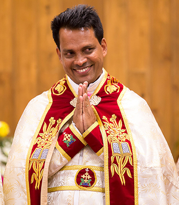 Father Jose Mathew Adoppilill, pastor of the new St. Jude Knanaya Church, receives his parishioners' applause during the dedication Mass.