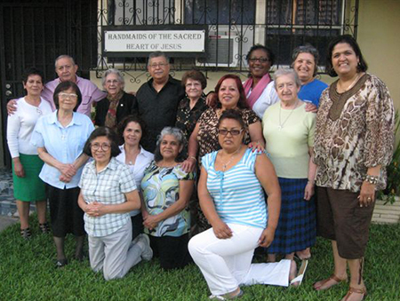 The three Handmaids of the Sacred Heart of Jesus working in Miami pose in front of their Miami Shores convent with a group of their lay associates. Sister Cecilia Chen is standing at left in front row; Sister María Jesús Sagaseta is standing second from right, and behind her is Sister Donatella De Marco.