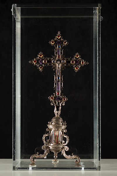 This is the crucifix-shaped reliquary that contains the first-class relic, a finger, of St. Augustine of Hippo, patron saint of the Diocese of St. Augustine. The crucifix is made of silver and adorned with precious stones. The reliquary dates back to 1904, with the name of Pope Pius X inscribed on it.