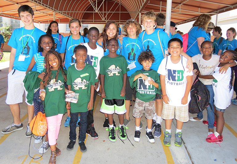 Volunteers from Peoria's Notre Dame High School and Illinois State University gather outside St. Mary Cathedral School after arriving from a field trip with the summer camp children. There were a total of 50 student volunteers every week, and approximately 10 other chaperones.