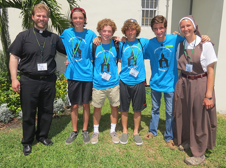 Posing for a photo outside St. Mary Cathedral School, from left: Father Adam Stimpson from Notre Dame High School in Peoria, Ill., with volunteers Joey Dixon, Mick Faley, George Jacob, Inigo Isla, and Sister Sara Kowal from the Servants of the Pierced Hearts, who works as a campus minister at the high school.