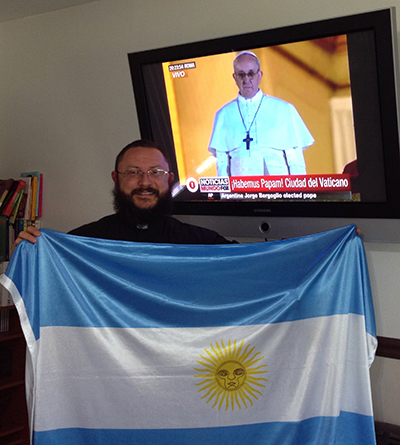 Father Jesús Alberto Bohórquez, administrator, St. Ann Mission with Argentina flag when Cardinal Jorge Mario Bergoglio was elected Pope and adopted the name of Pope Francis. Father Bohórquez will accompany his parishioners on the pilgrimage to Philadelphia, with a return stop to see the historic sites in Washington, D.C.