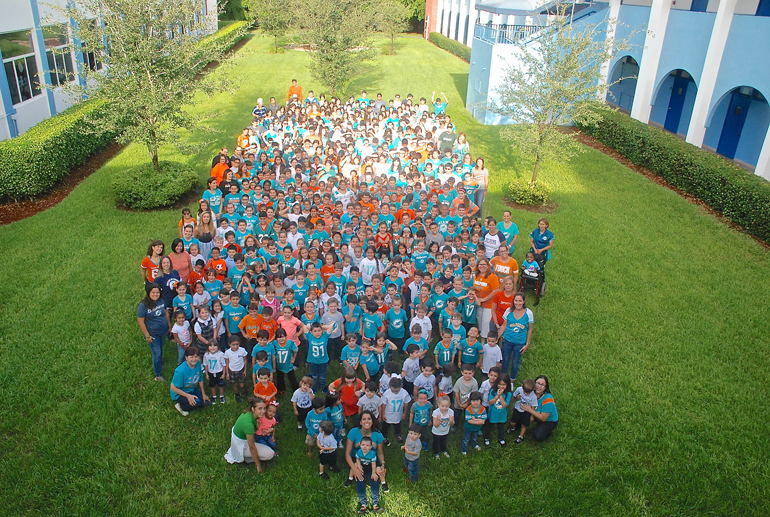 Wearing the Miami Dolphins team colors, the students, faculty and staff at Immaculate Conception School stand together to make a sea of white, teal, and orange. The school kicked off the opening of the NFL season with a "Dolphins Day."