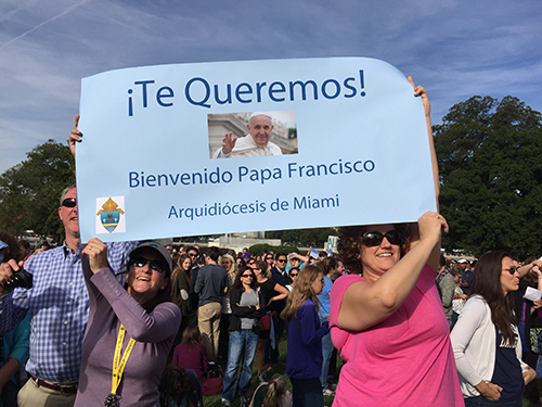 Los peregrinos de Miami sostienen su cartel para el Papa Francisco antes de su arribo a los jardines del lado  oeste del Capitolio estadounincence.