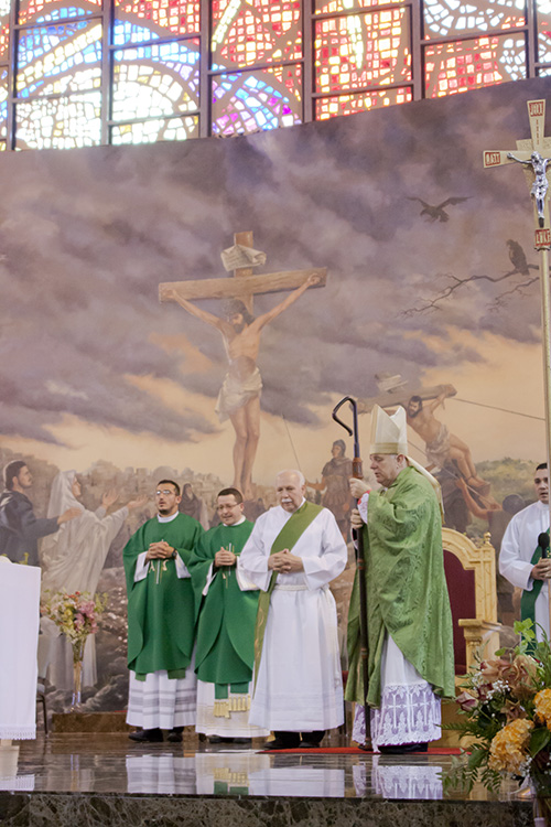 Archbishop Thomas Wenski prays during the final blessing at the Mass celebrating the 70th anniversary of St. John the Apostle Church in Hialeah. At left are Father Ivan Rodriguez, parochial vicar, Father Hector Perez, pastor, and Deacon Julke Llorens.