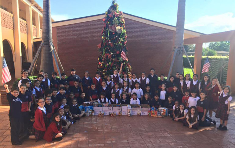 St. Brendan Elementary third graders raise flags during the holiday season in support of the "Adopt-a-Platoon" charity that they are supporting this year.