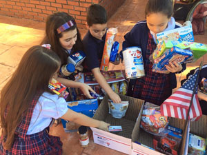 St. Brendan Elementary third graders prepare the goody boxes that they will be sending to soldiers as part of the "Adopt-a-Platoon" charity that they are supporting this year.