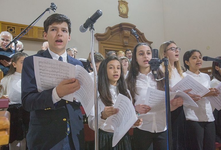 Members of St. Theresa School's Schola Cantorum sing during the 90th anniversary Mass; from left: Marcel Van Hemert, 13, student council president; Anne Marie Issa, 13; Theresa Cortinas, 13, who was named after the school; Jacqueline Cotilla, 12; and Diana Durand, 13.