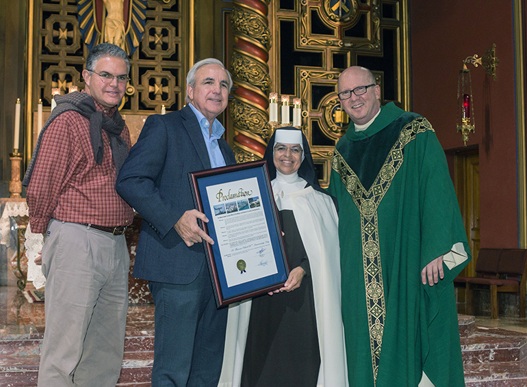 Miami Dade County Commissioner Bruno Barreiro and Miami Dade County Mayor Carlos Gimenez, present a proclamation honoring St. Theresa School's 90th anniversary to Carmelite Sister Caridad Sandoval, the school's principal, and pastor Father Michael Davis.