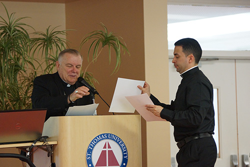 Father Jose Alfaro, right, pastor of Blessed Trinity in Miami Springs, presents his team's evangelization plan to Archbishop Thomas Wenski.