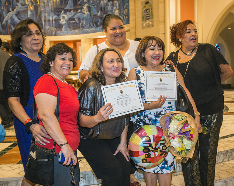 Maria Arguello and Nancy Reyes, newly-commissioned ministers from St. Joachim Church in southern Miami-Dade County, pose with friends after the Mass.