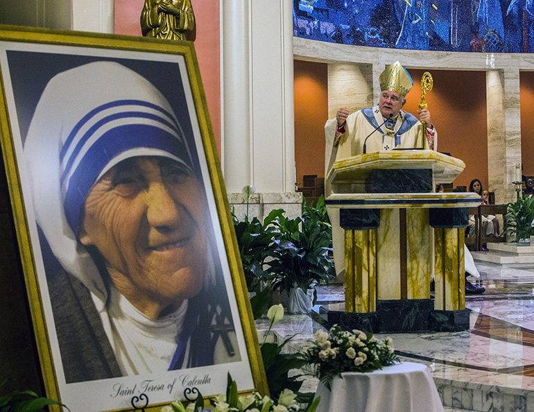 An image of Mother Teresa, now St. Teresa of Kolkata, adorns the front of the sanctuary at St. Mary Cathedral as Archbishop Thomas Wenski preaches the homily.