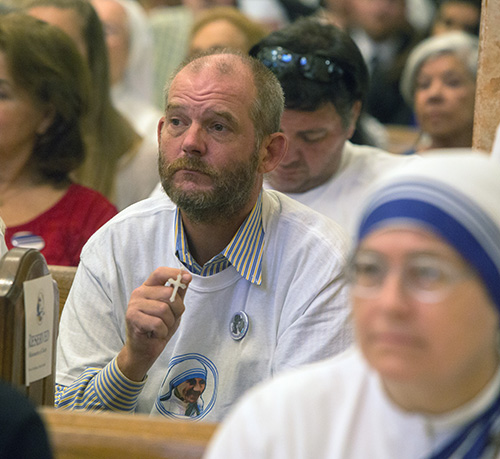 A client of the Missionaries of Charity soup kitchen in Miami prays during the Mass.