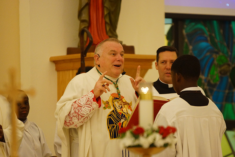 Archbishop Thomas Wenski speaks to the congregation during New Year's Eve midnight Mass at Notre Dame d'Haiti Church in Miami. In addition to the solemnity of Mary, the Mass also marks the anniversary of Haiti's independence.