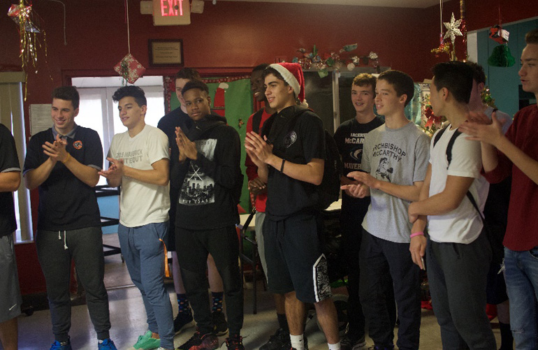 Basketball players from Archbishop McCarthy High sing Christmas carols at The Baby House. From left: Daniel Enriquez, Christian Avila, Luke Nesselt, Saeme Ennis, Jonathan Joseph, Santi Cucalon, Evan Welch, Matthew Albury, Nico Chee, Jack Rivera and Austin McClean.