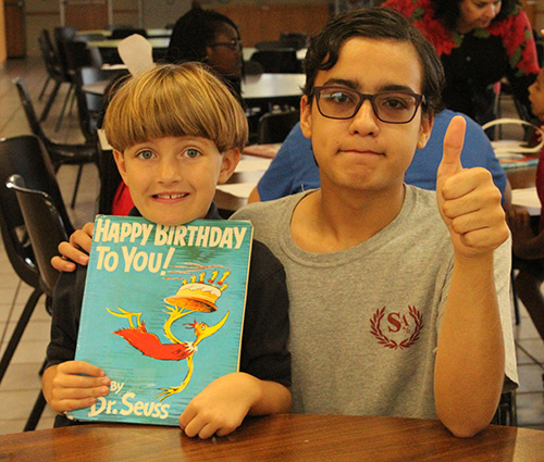 St. Andrew School kindergartener Varian Lambert, left, and eighth grader Henry Santos give a thumbs up to celebrating children's author Dr. Seuss' 113th birthday March 2.