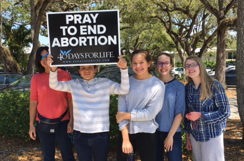 From left: Natalie Bauta, John Bauta, Mary Bauta, Grace Chaffins and Emily Chaffins take part in the 40 Days for Life vigil outside Eve Medical Center in Kendall. The vigil began Ash Wednesday and ended Palm Sunday, with participants taking turn to pray every day from 7 a.m. to 7 p.m.