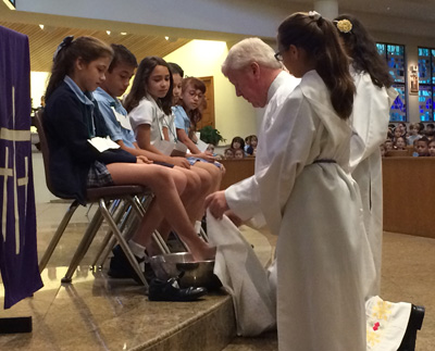 Father Ed Prendergast, pastor of St. Bonaventure, washed the feet of 12 students during a Holy Week school Mass, April 12.