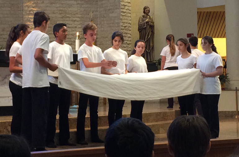 Eighth grade students from St. Bonaventure reenact the Last Supper during a mime presentation of the Passion and Death of Jesus.