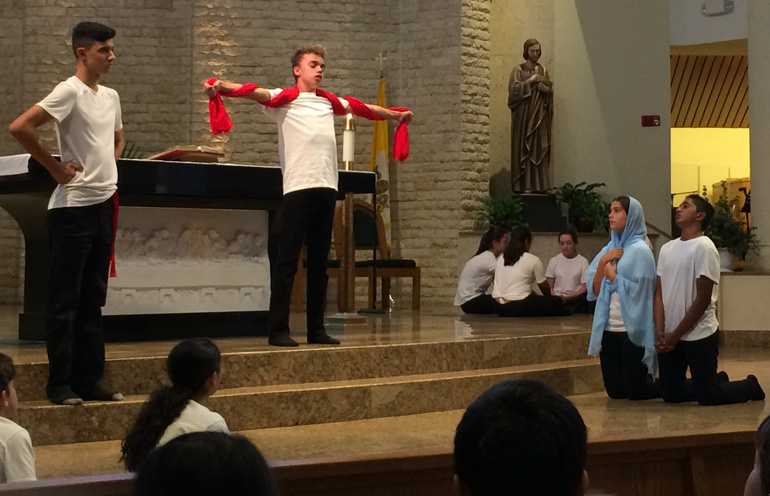 Eighth grade students from St. Bonaventure reenact the crucifixion during a mime presentation of the Passion and Death of Jesus.