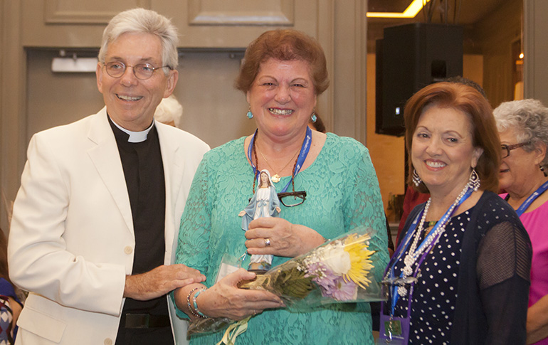 Nancy Nesselt receives the Our Lady of Good Counsel Award at the Miami Archdiocesan Council of Catholic Women's 59th annual convention. At left is Father Michael J. Greer, the group's spiritual advisor, and at right is MACCW President Sharon Utterback. The convention took place at the DoubleTree by Hilton in Deerfield Beach.