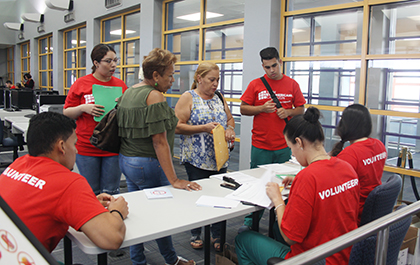 Los voluntarios de la Campaña Nuevos Americanos y estudiantes de enfermería de Miami Dade College, en Homestad, acompañan en el proceso final de completar los requisitos para la ciudadanía a Ramona Martínez (centro), quien asistió a la campaña de ciudadanía con su cuñada, Ana Rosa Arthur.