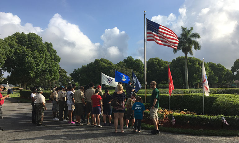 Broward Scout troops raise the flag and begin their annual tradition of placing individual flags on the graves of every soldier buried at Our Lady Queen of Heaven Cemetery in North Lauderdale.