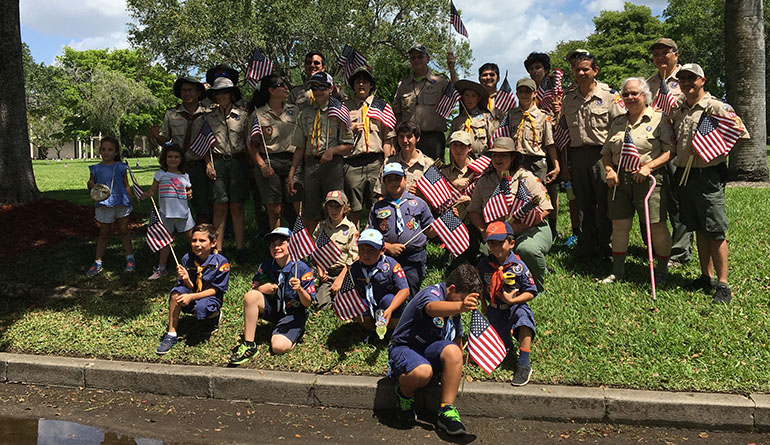 Scouts begin to go about their annual tradition of placing individual flags on the graves of every soldier buried at Our Lady of Mercy Cemetery in Doral.