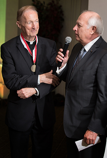 Malta representative Mark Wolff presents Father Patrick O'Neill with the American Association of the Order of Malta's highest honor, the President's Award.