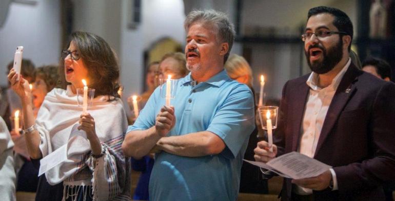 Congregants take part in a candlelighting during the recent Patriotic Prayer Service at Little Flower Church in Coral Gables. From left are Marilyn Becerra, Frank Paredes and Jonathan Sanchez.