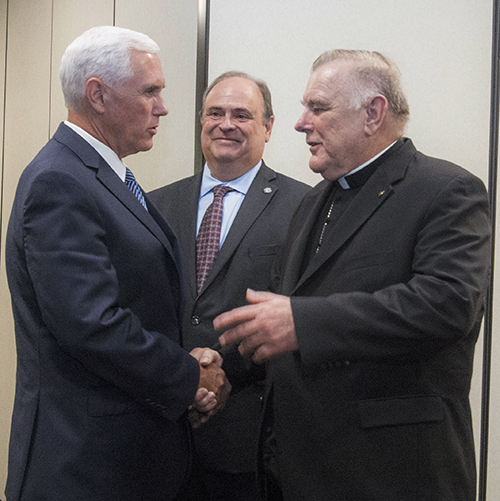 Archbishop Thomas Wenski greets Vice President Mike Pence as Juan Carlos Bermudez, mayor of Doral, looks on.