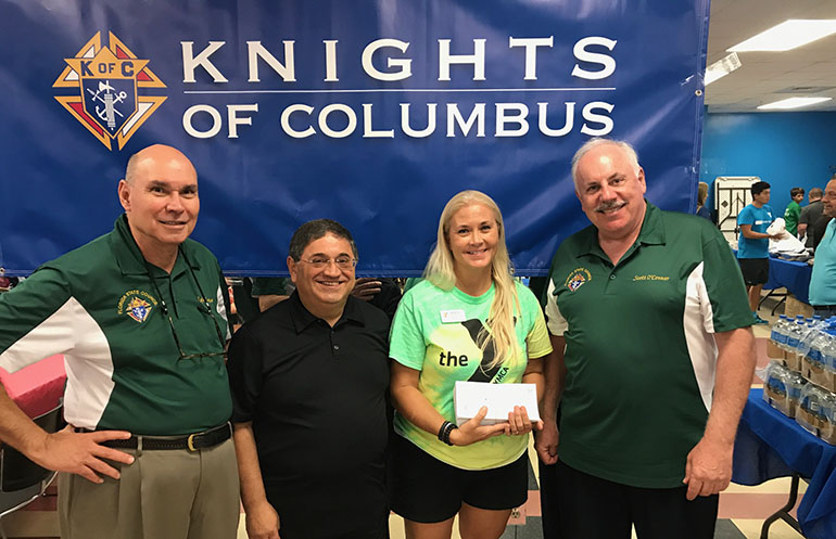 Miami Auxiliary Bishop-elect Enrique Delgado poses with representatives of the Florida State Council of the Knigths of Columbus and the Weston YMCA during a recent outreach to families relocated to South Florida from Puerto Rico after Hurricane Maria; from left: Rafe Lopez, Knights' state treasurer, Bishop-designate Delgado, Angie Miller, family services director of the Weston YMCA, and Scott O'Connor, Knights' state secretary.