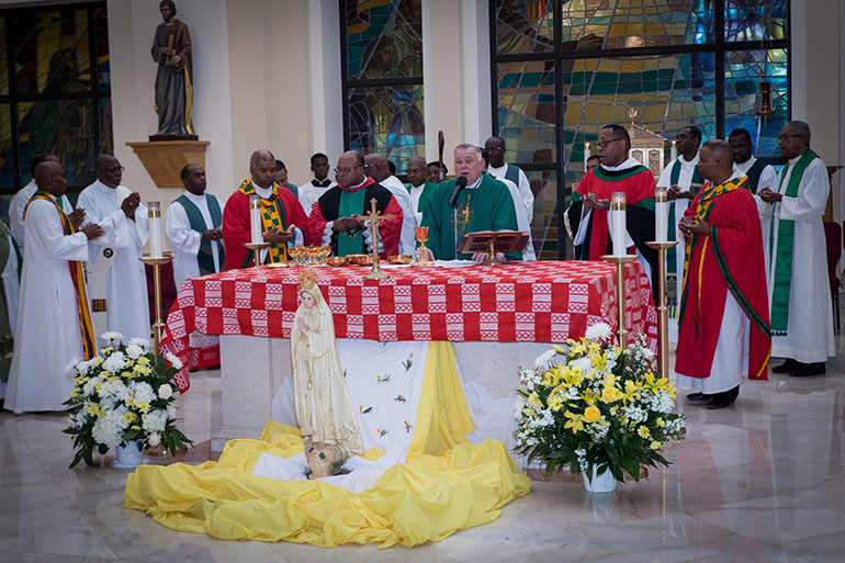 Archbishop Thomas Wenski, surrounded by black priests from throughout the U.S. and South Florida, presides during the Mass celebrated at Notre Dame d'Haiti Church in Miami during the 14th National Black Catholic Men's Conference.