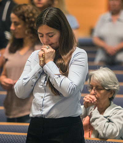 Adriana Gonzalez prays the rosary during the prayer service for immigrants held at St. John Neumann Parish, Palmetto Bay, on the feast of the Assumption.