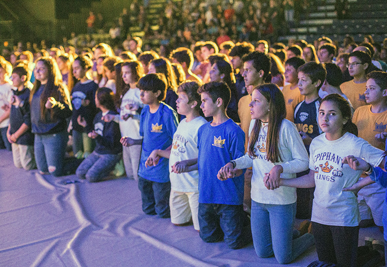 Teenagers kneel during adoration at Mercy Night.