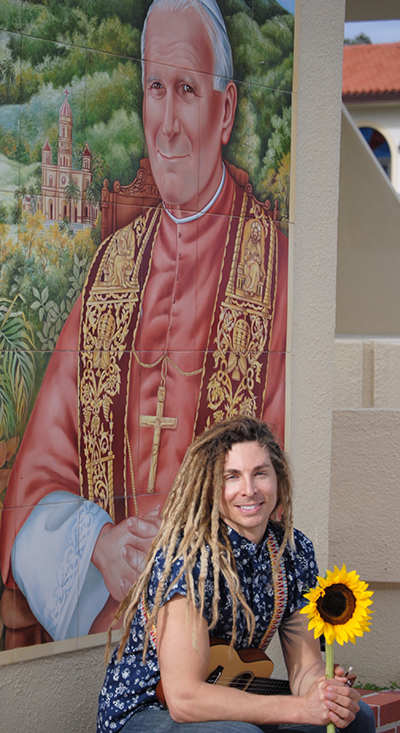 Despite success as a pop/reggae artist, Zander has traded the ways of the world to share God’s message through his music. Here he is pictured beneath a mosaic of St. John Paul II at the Shrine of Our Lady of Charity in Miami.