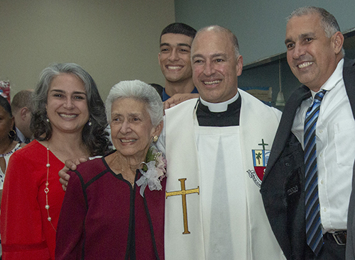 Father Elkin Sierra takes a break from giving out blessings to pose with his family, from left: his sister, Ana, his mother, Stella, one of his nephews, Vincent, 18, and his brother, Luis, who also became a firefighter/paramedic.
