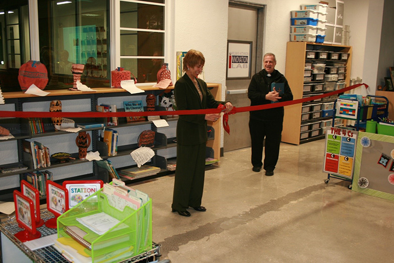 Isabel Gonzalez-Jettinghoff, widow of William B. Hutchinson, cuts the ribbon after Msgr. Pablo Navarro, pastor, blessed St. John Neumann School's new William B. Hutchinson Innovation Lab, Jan, 28, 2020.