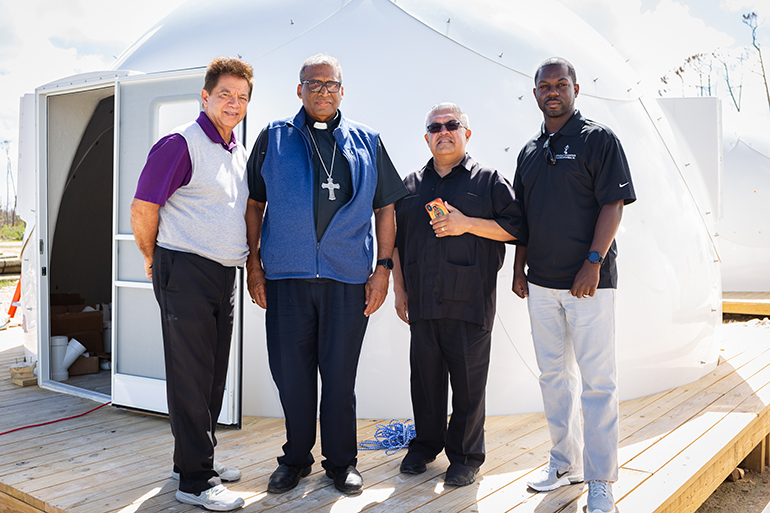 Nassau Patrick Archbishop Pinder leads a small delegation of Archdiocese of Miami Catholic Charities senior staff through Nassau, Grand Bahama and Great Abaco Island Feb. 19-21, 2020, including CEO Peter Routsis-Arroyo, left, and Msgr. Roberto Garza, board chairman for Catholic Charities Miami. Marco Greenslade, director of finance for Catholic Charities Miami. They are seen here at new temporary housing structures on Abaco.