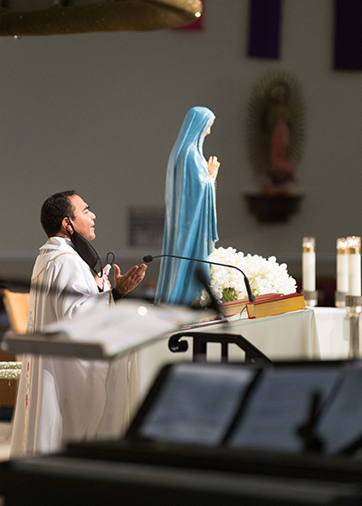 Father Wilfredo Contreras, pastor of San Isidro, leads the Pompano Beach community in prayer at the Mass that preceded the inauguration of a renewed grotto and enthronement of a refurbished statue on Dec. 8, 2020, the feast of the Immaculate Conception. Both the grotto environs and the statue were refurbished this year by parishioners.