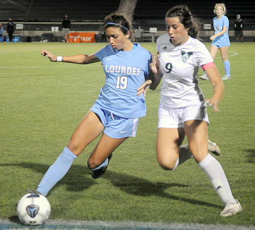 Lourdes sophomore midfielder Katerina Puig (19) and Venice's Rachel Dalton jostle for the ball during the first half of Our Lady of Lourdes Academy's 0-0, 3-1 penalty-kicks loss to Venice,  March 5, 2021 in the FHSAA Class 6A Girls Soccer Championship Game at Spec Martin Stadium in DeLand.