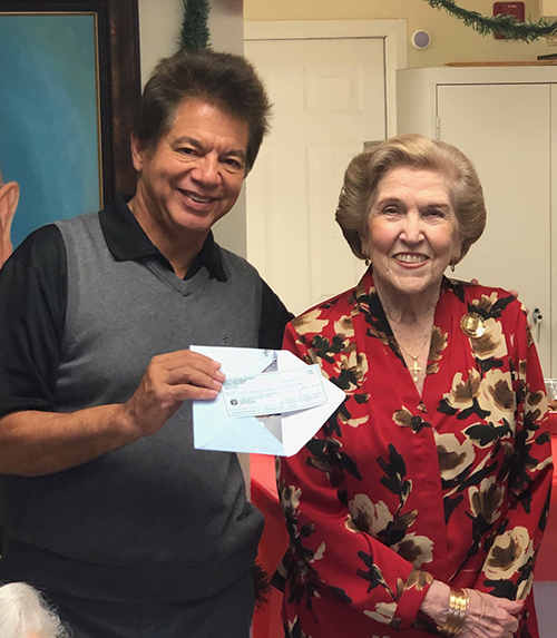 Catholic Charities of Miami CEO Peter Routsis-Arroyo poses with former Centro Hispano Catolico Ladies Auxiliary president Emma McCormack in a 2018 gathering. In December 2020 the ladies presented Catholic Charities with a final donation to continue the work of the historic Miami child care center.