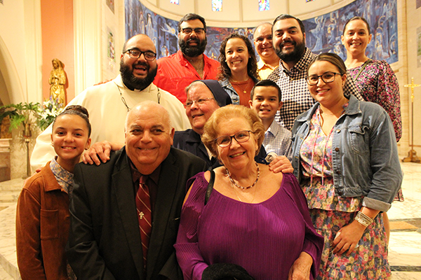 Sister Olga Gomez, center, poses with members of her family, including her nephew, Father Matthew Gomez, left, director of vocations at the Archdiocese of Miami, who came to the Mass celebrating 50 years since the Daughters of Charity of St. Vincent de Paul arrived in Miami. Archbishop Thomas Wenski and other archdiocesan priests celebrated the Mass at St. Mary Cathedral on Aug. 14, 2021.